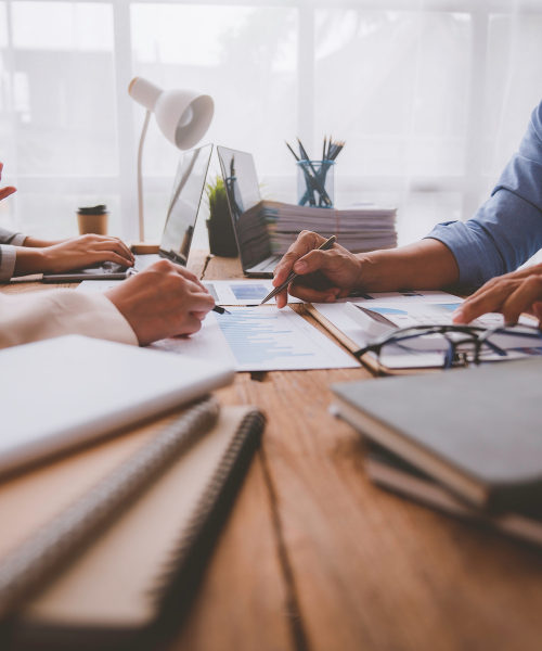 cropped image of two peoples hands reviewing documents on a table